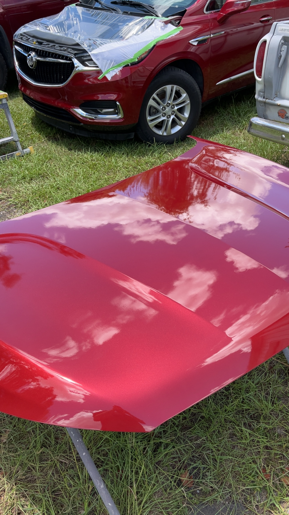 Freshly painted red hood panel reflecting clouds - quality paint work at The Drip Auto Body Leesburg FL