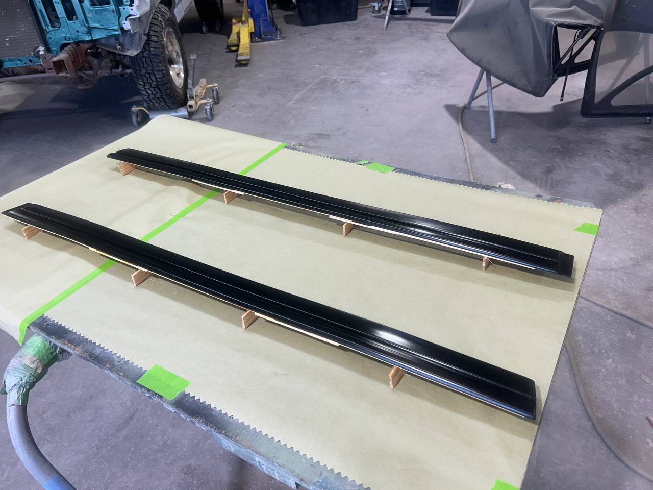 Jeep Wrangler side rocker trim rails freshly painted gloss black at The Drip Auto Body