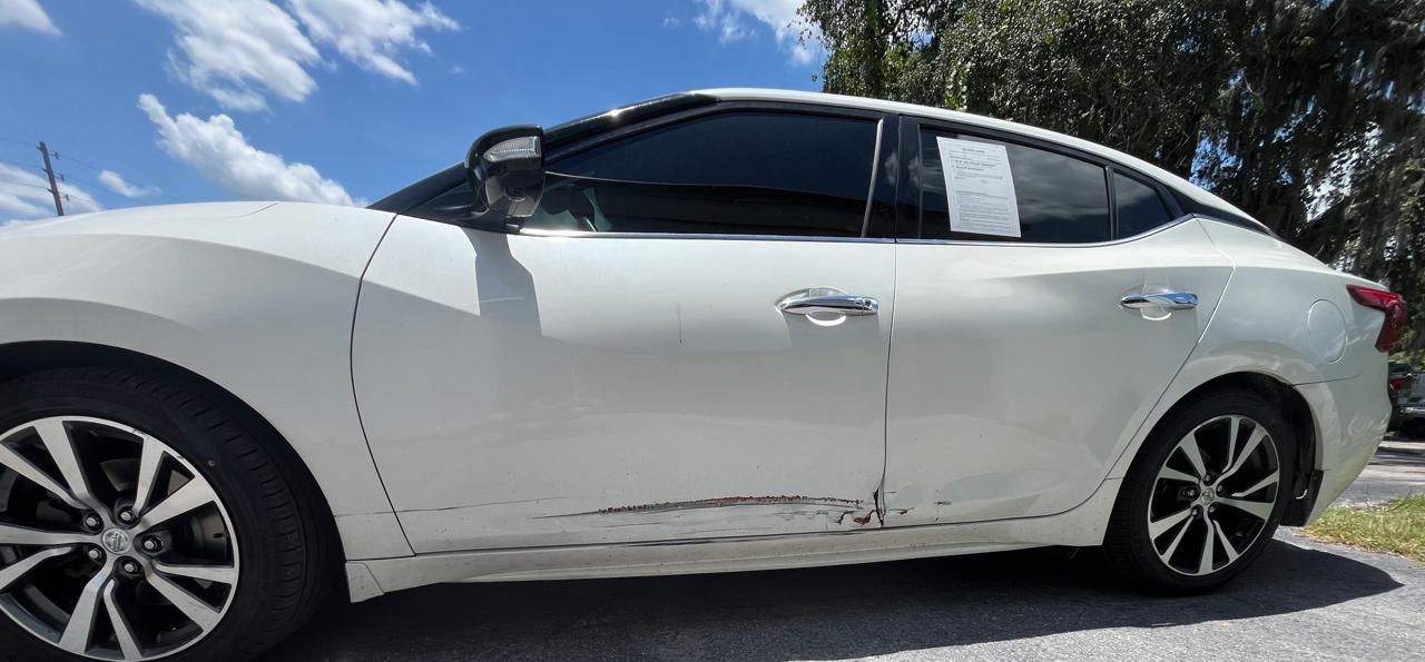 Nissan Maxima Platinum side damage close-up showing scrape along doors and rocker panel