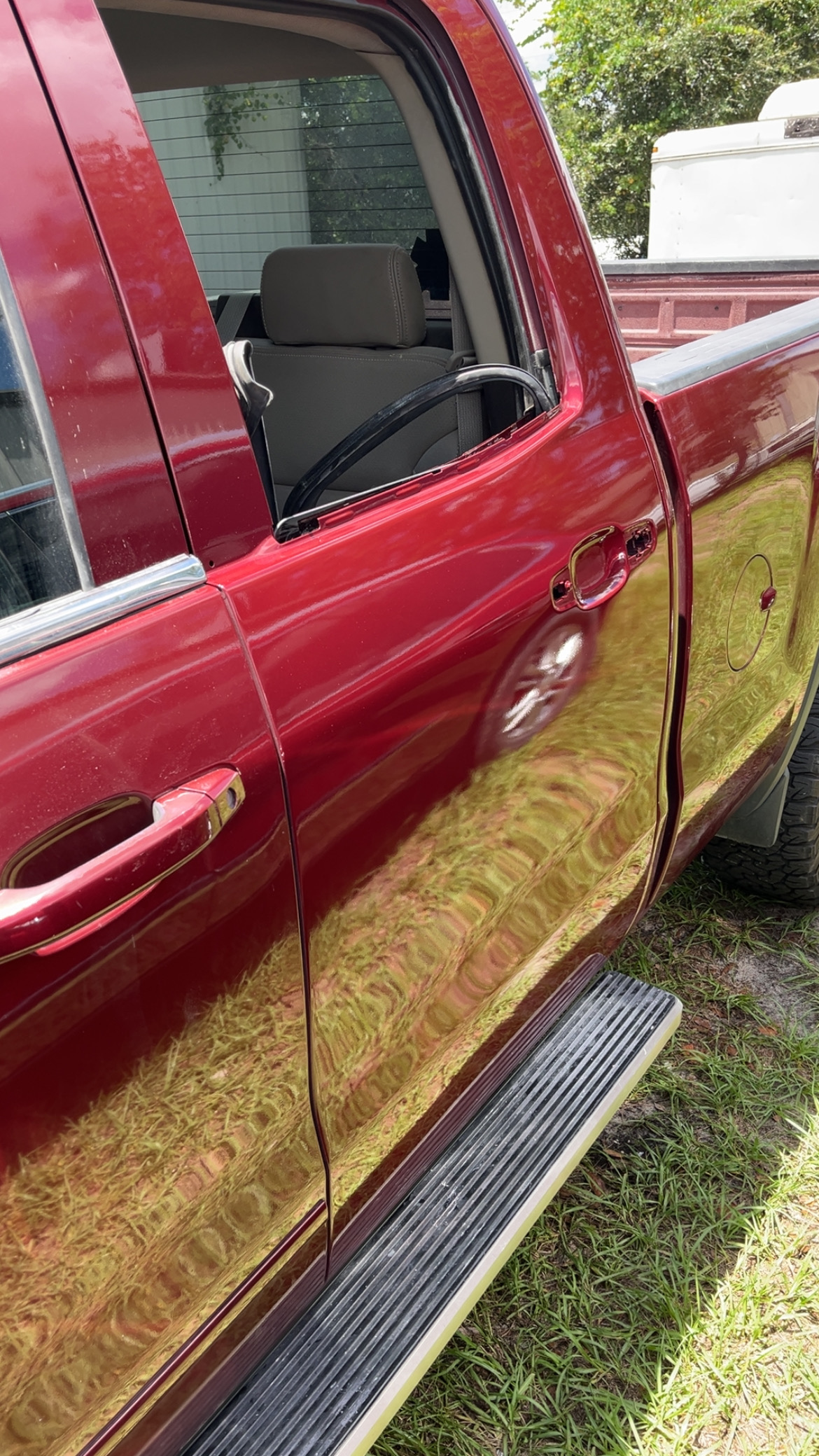 Close-up of freshly painted Chevy Silverado door showing mirror-like red finish at The Drip