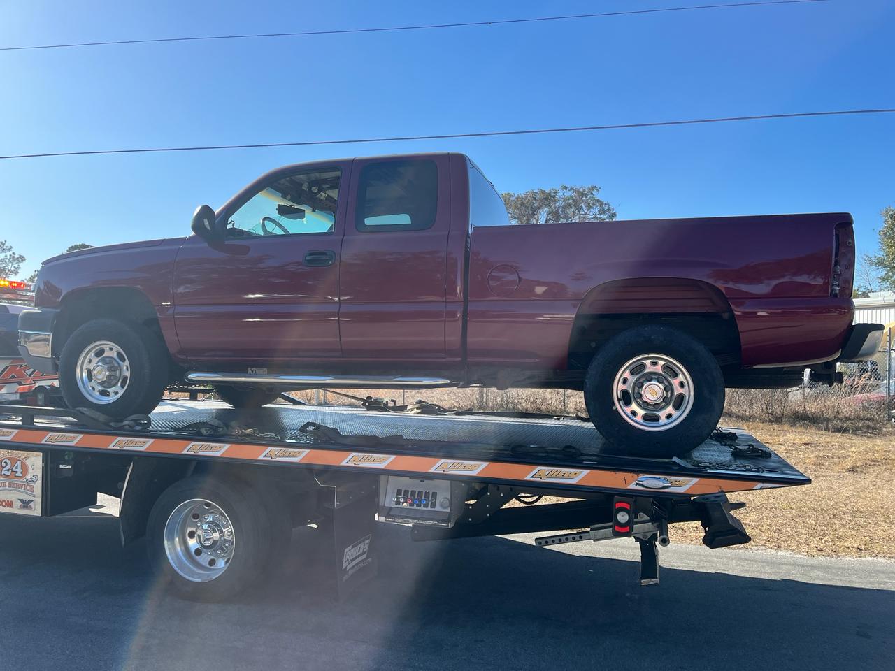 Chevy Silverado arriving on flatbed for collision repair at The Drip Auto Body Leesburg FL