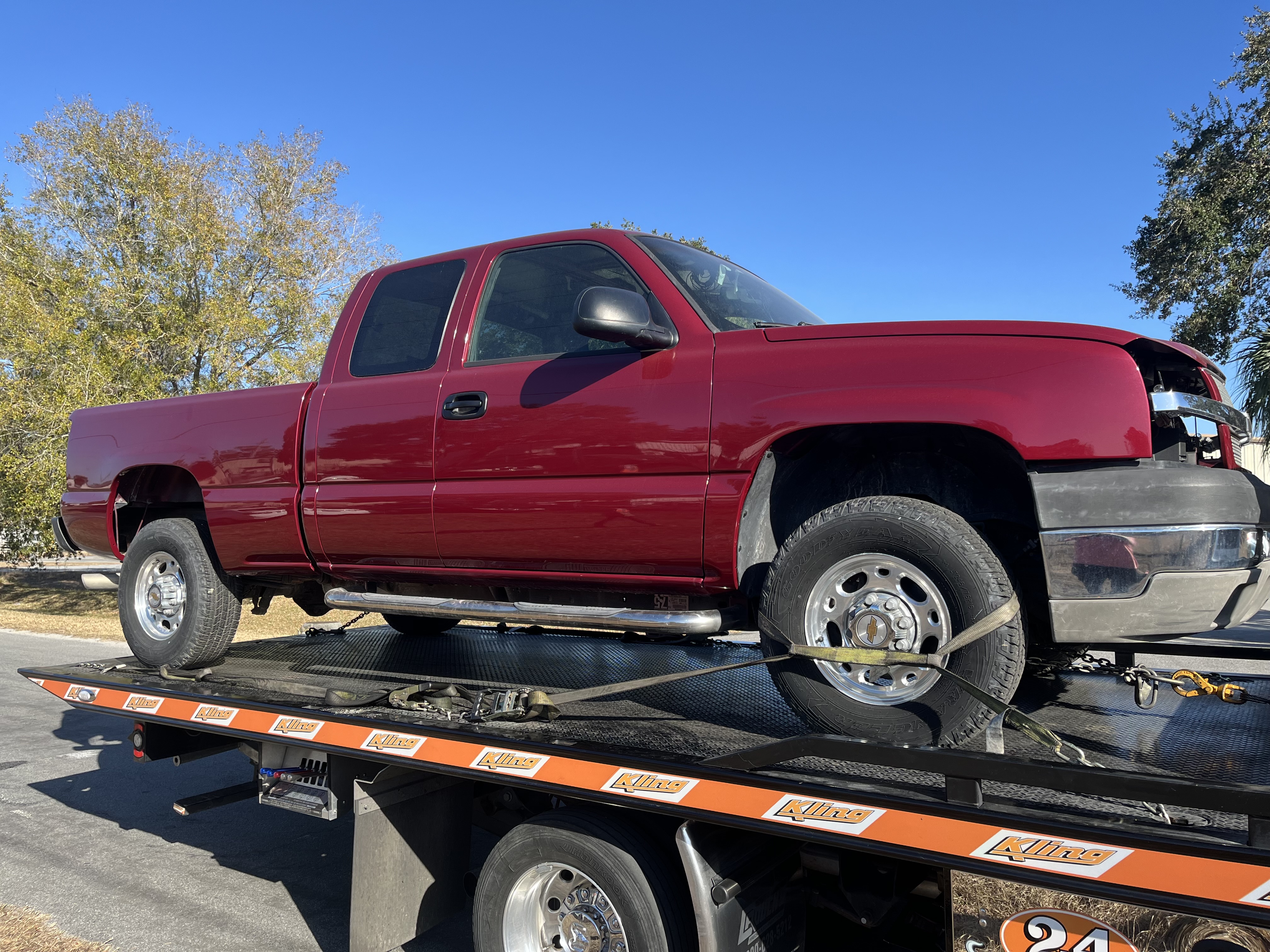 Chevy Silverado extended cab on flatbed arriving for restoration at The Drip Auto Body Leesburg FL