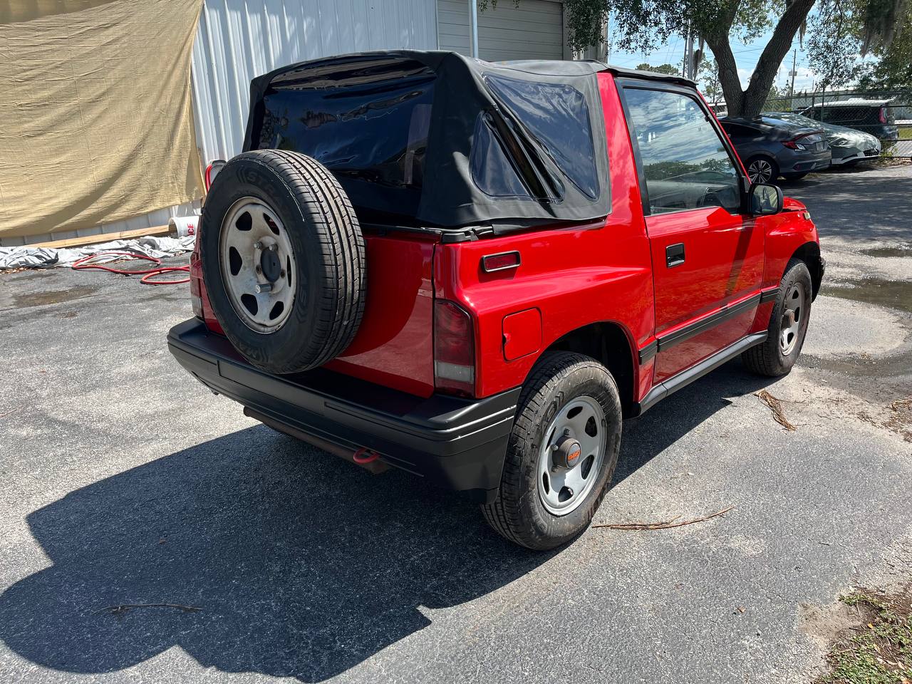 Geo Tracker soft-top completed red paint job rear view at The Drip Auto Body Leesburg FL