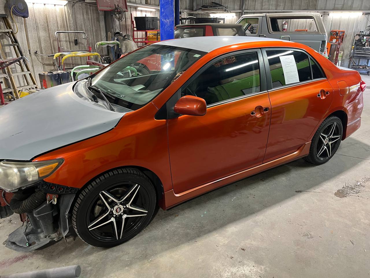 Toyota Corolla during paint - hood and fender in primer